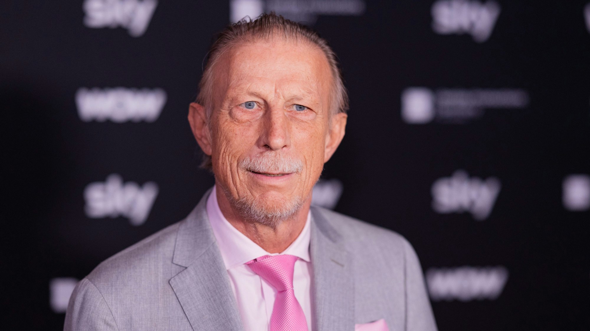 Christoph Daum steht auf dem Roten Teppich.