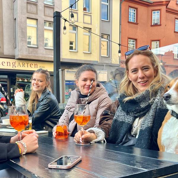Fünf junge Frauen im Straßenlokal trinken Aperol