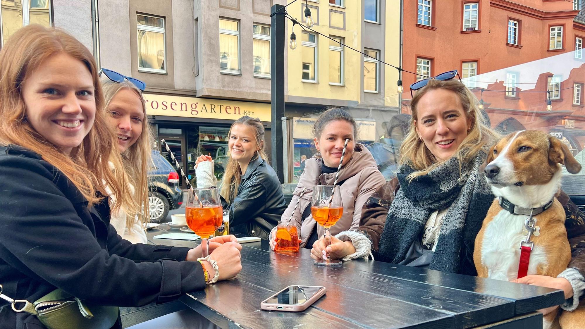 Fünf junge Frauen im Straßenlokal trinken Aperol