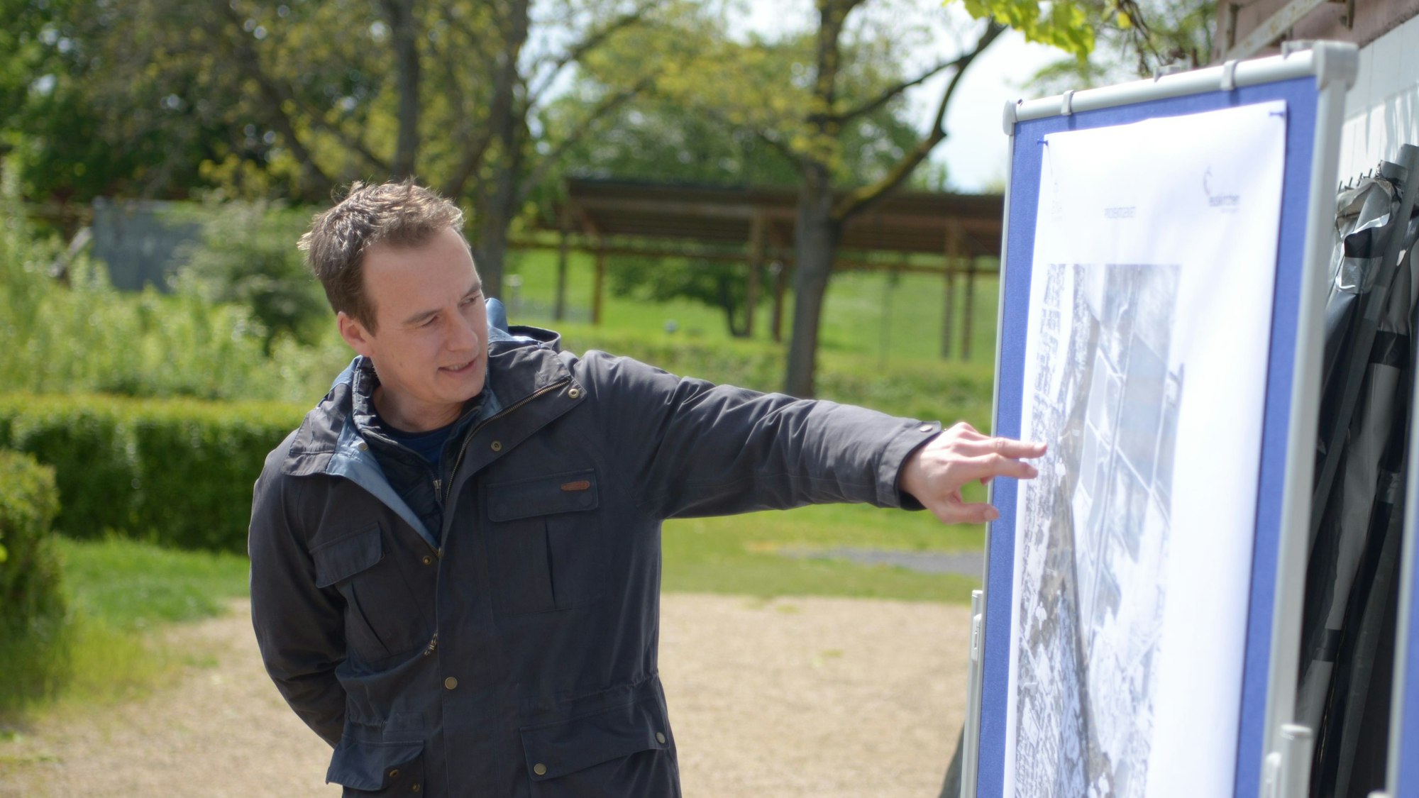 Simon Gammersbach deutet auf eine Schautafel.