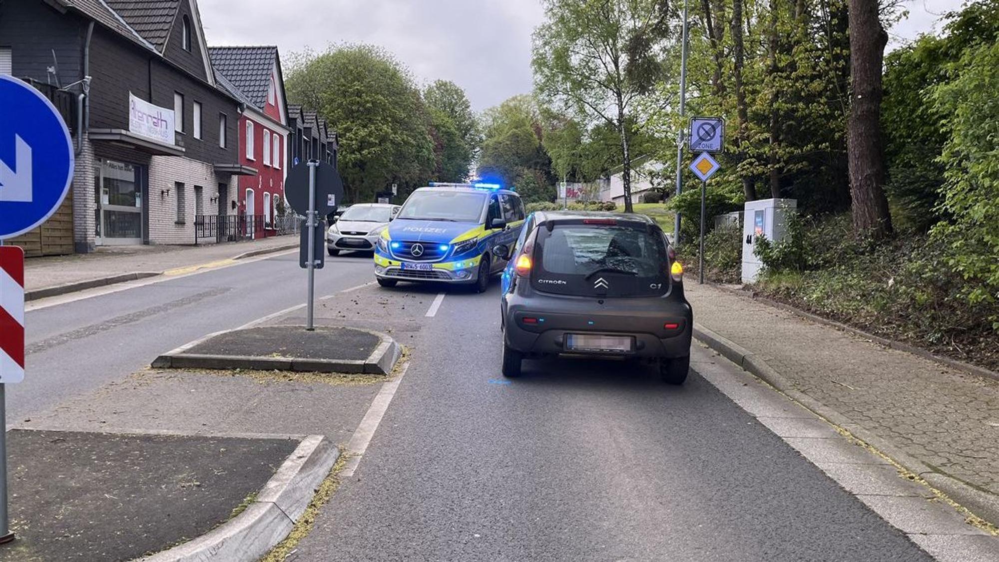 Ein Fußgängerüberweg, ein Auto und ein Polizeifahrzeug.