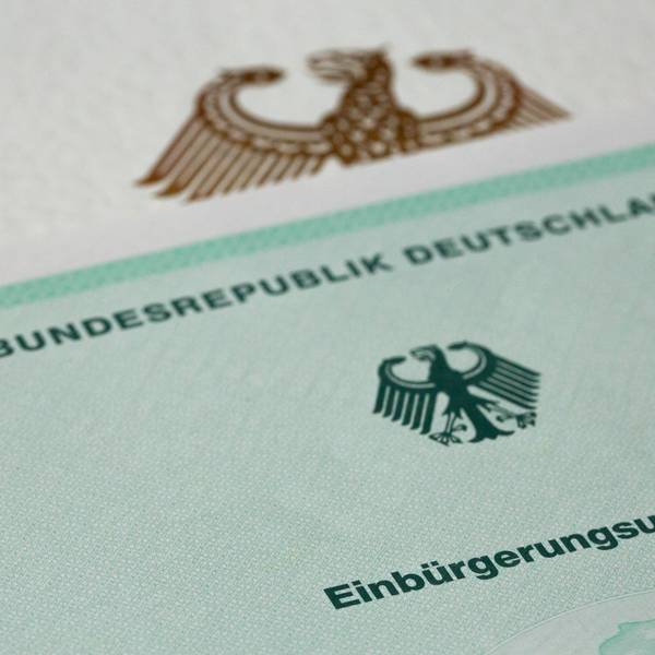 Eine Einbürgerungsurkunde der Bundesrepublik Deutschland liegt auf einem Tisch.