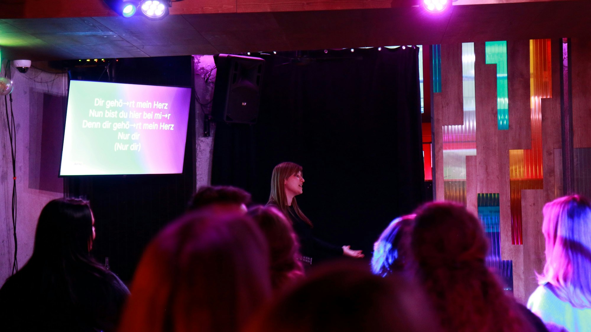 Ein Bildschirm mit Text hängt über den Köpfen der Menge.