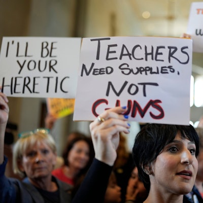 Menschen halten verschiedene Schilder gegen das neue Gesetz in die Höhe.