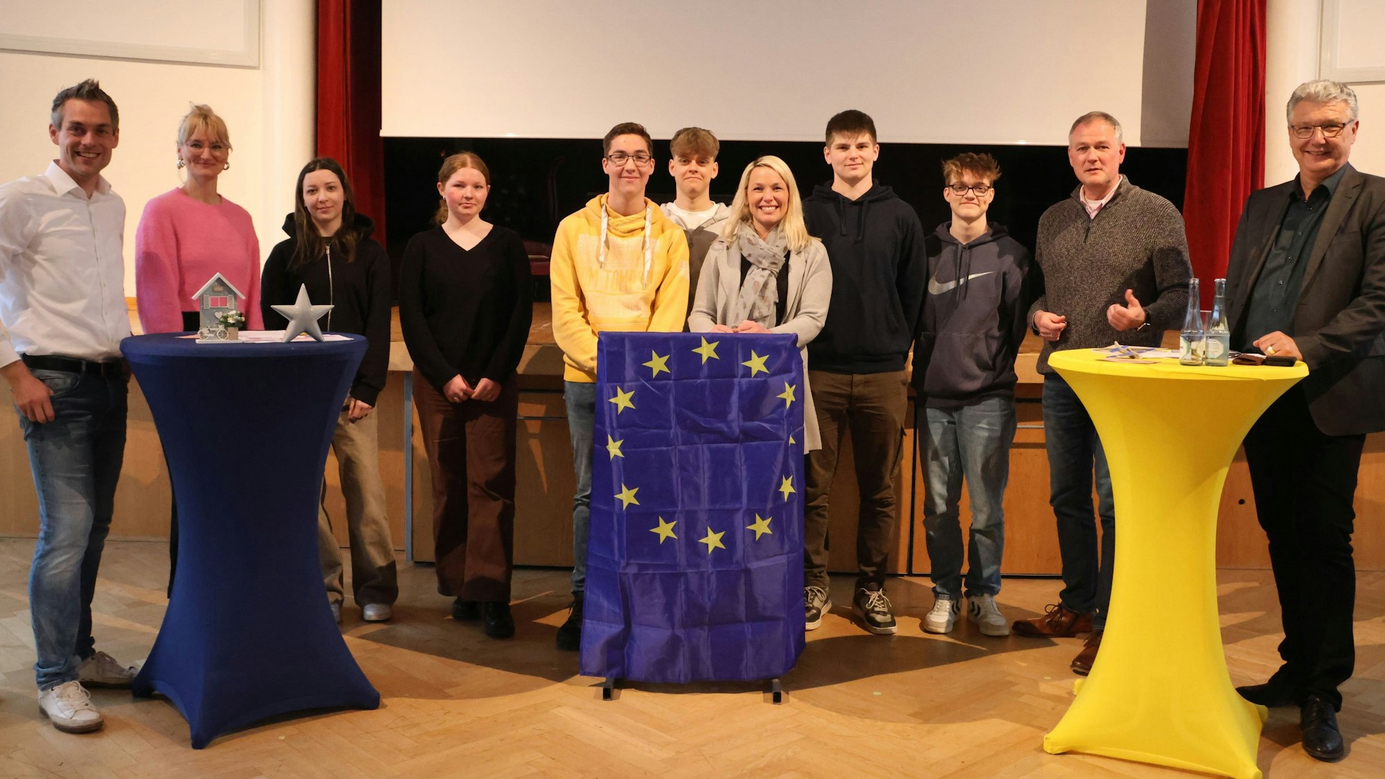 Die Teilnehmer haben sich an Stehtischen gruppiert.