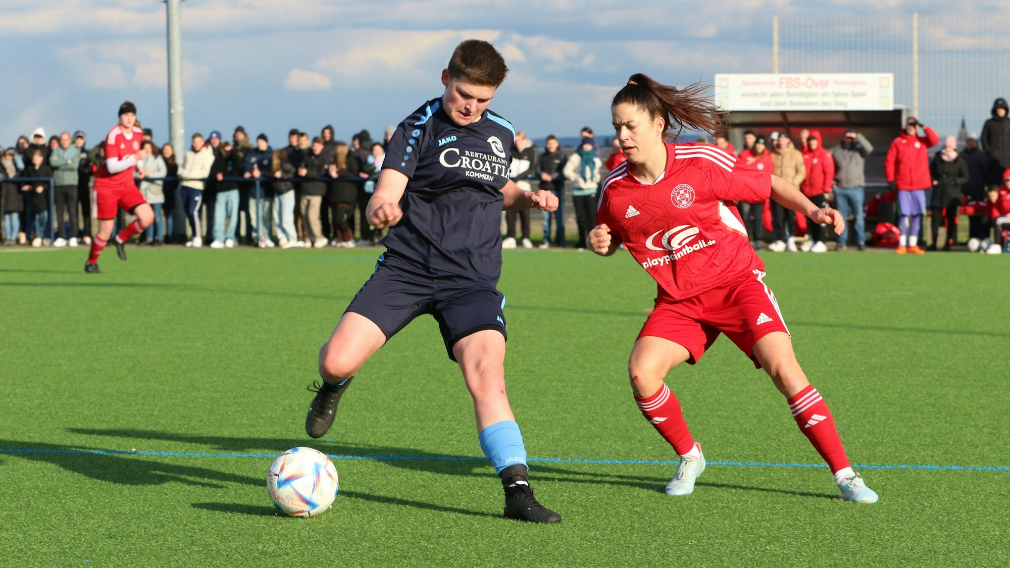 Kommerns Laurie Simon (l.) war läuferisch stark unterwegs und belohnte sich mit dem Tor zum zwischenzeitlichen 3:2. Im Hintergrund sind die zahlreichen Zuschauer zu erkennen.
