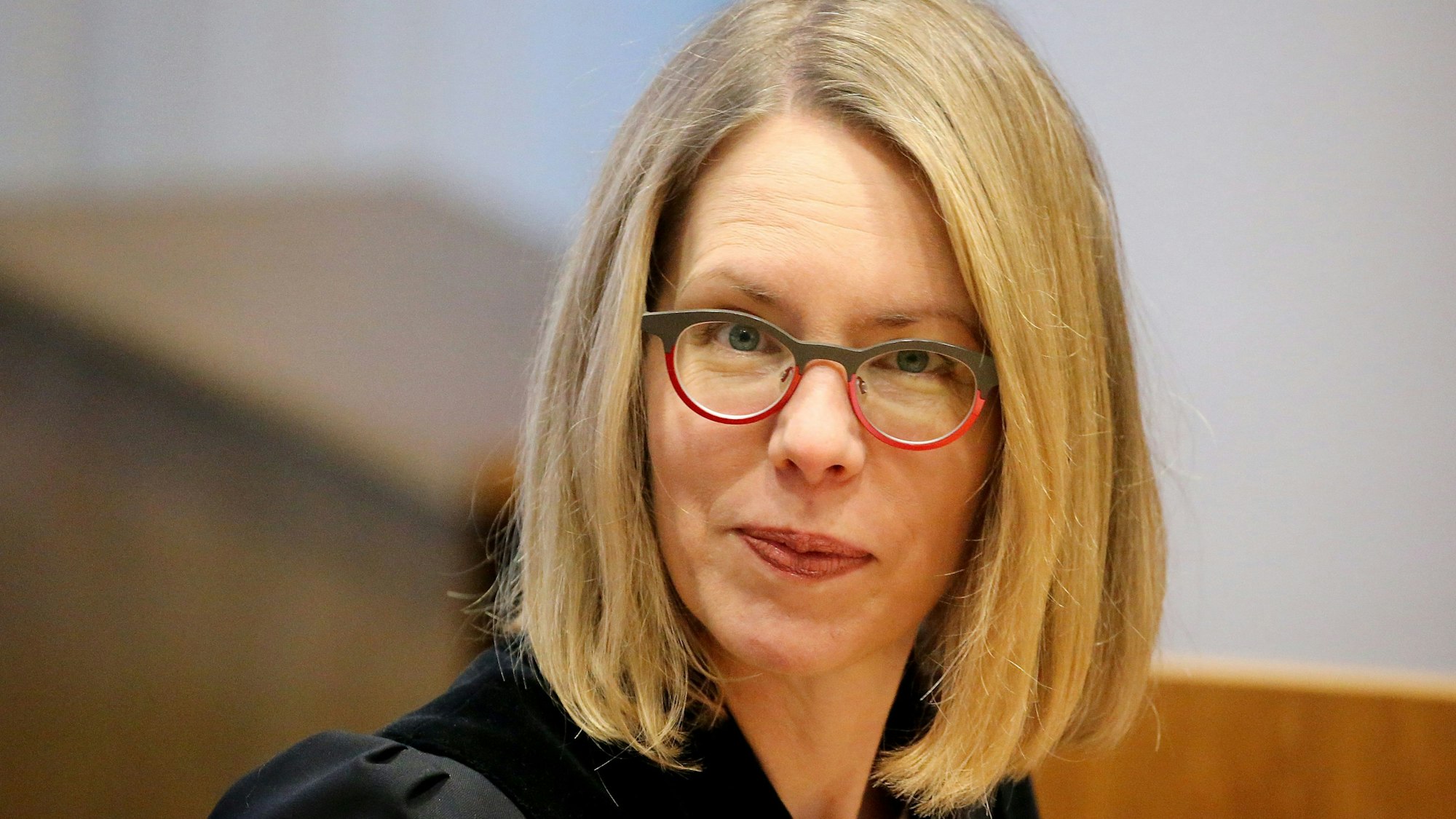 Oberstaatsanwältin Anne Brorhilker sitzt in einem Gerichtssaal. Zu sehen ist ihr Gesicht sowie die mit einer schwarzen Robe bedeckten Schultern. Sie trägt eine Brille.
