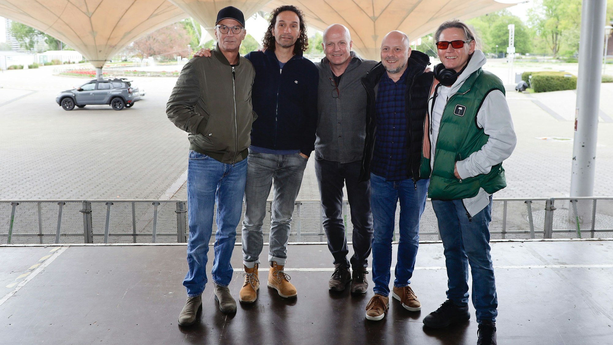 Die fünf Bandmitglieder stehen auf der Bühne im Tanzbrunnen und schauen in die Kamera.