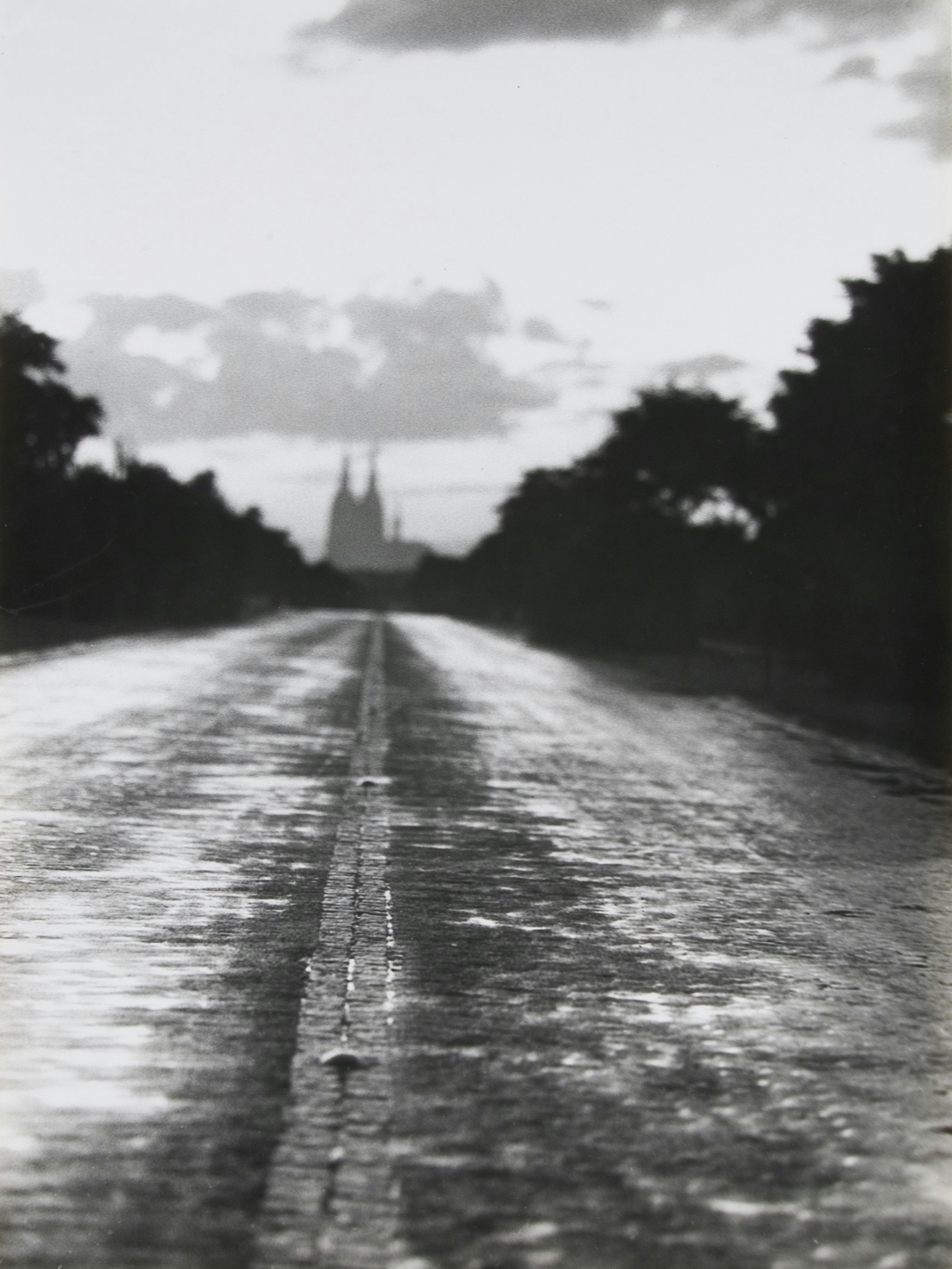 Am Ende einer Straße ist am Horizont der Kölner Dom zu sehen.