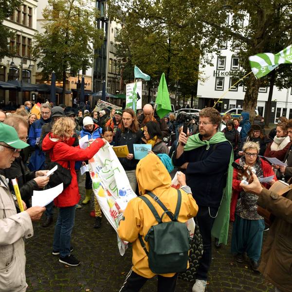 Menschen demonstrieren auf einem Platz in Köln.