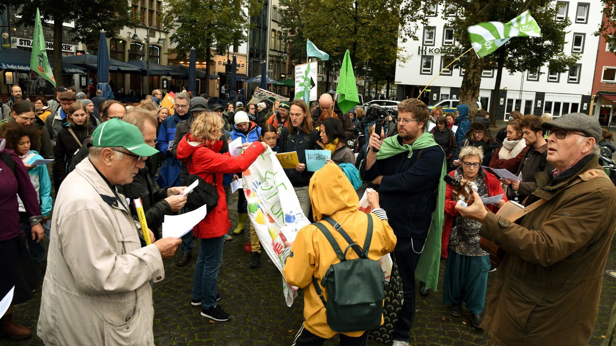 Menschen demonstrieren auf einem Platz in Köln.