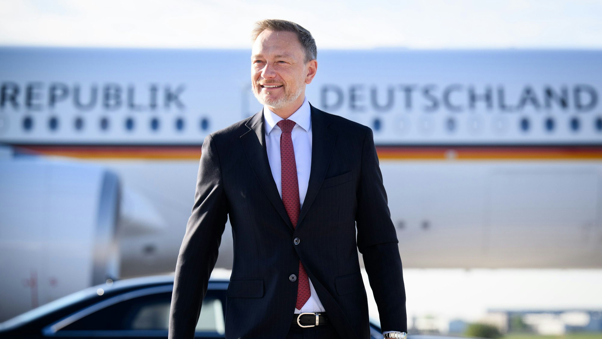 Christian Lindner steigt auf dem militärischen Teil vom Flughafen Berlin-Brandenburg in ein Flugzeug.