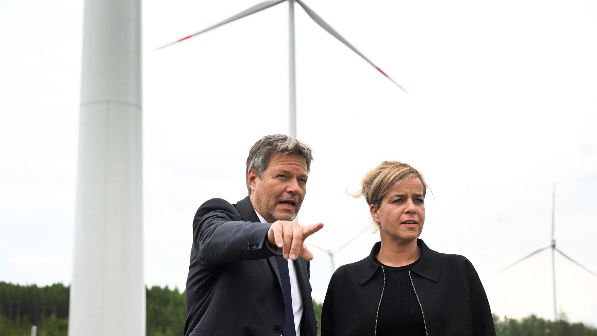 06.06.2023, Nordrhein-Westfalen, Bad Berleburg: Robert Habeck (l), Bundeswirtschaftsminister, und NRW-Wirtschaftsministerin Mona Neubaur (beide Grüne), stehen vor Windrädern zur Stromerzeugung. Die Wittgenstein Gruppe sowie der Landesverband Erneuerbare Energien NRW nehmen den seit Herbst 2022 bestehenden Wald-Windpark Arfeld mit vier Windrädern offiziell in Betrieb. Foto: Federico Gambarini/dpa +++ dpa-Bildfunk +++