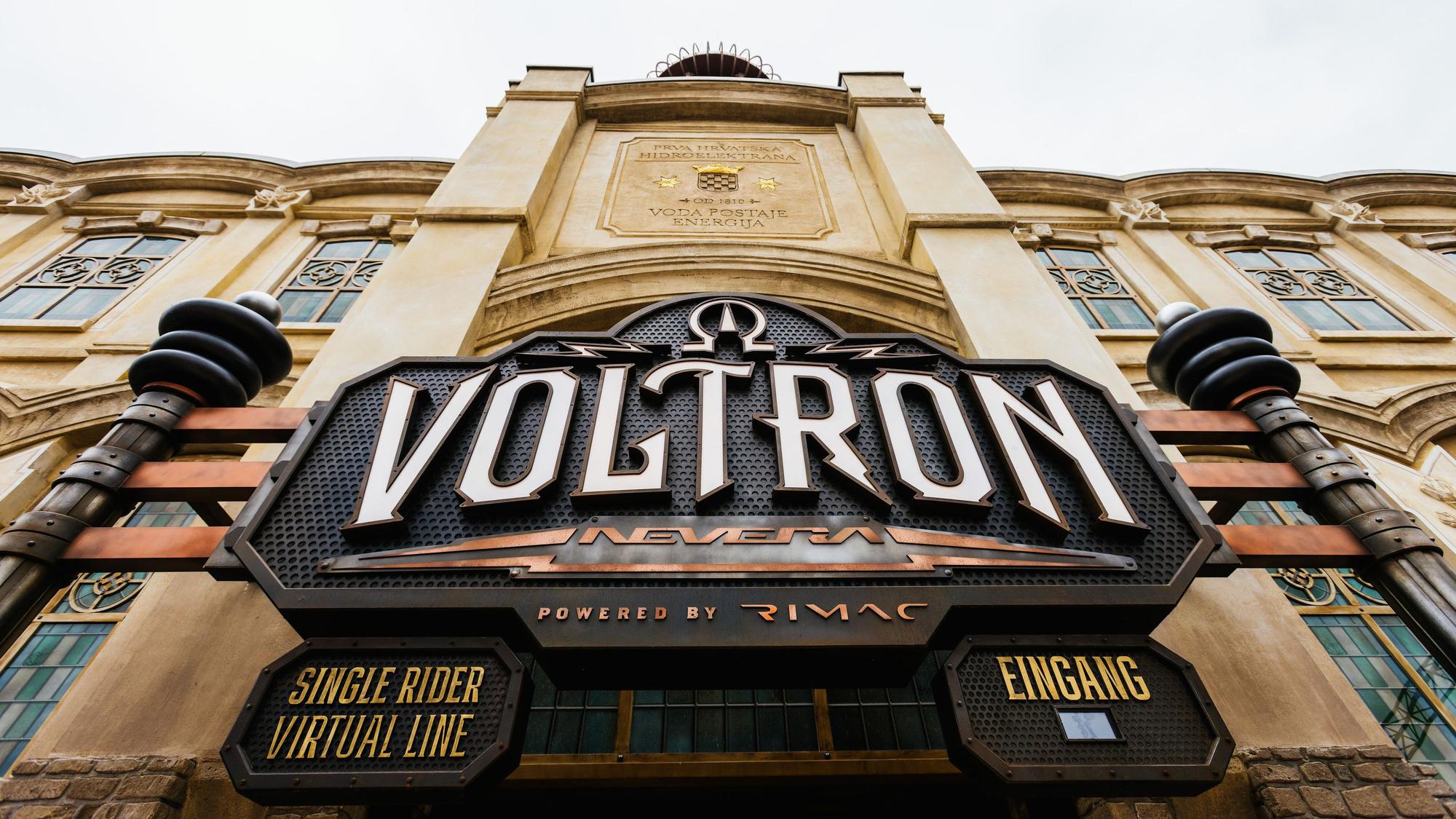 Das Logo der Achterbahn Voltron Nevera ist über dem Eingang zum Bahnhofsgebäude zu sehen.