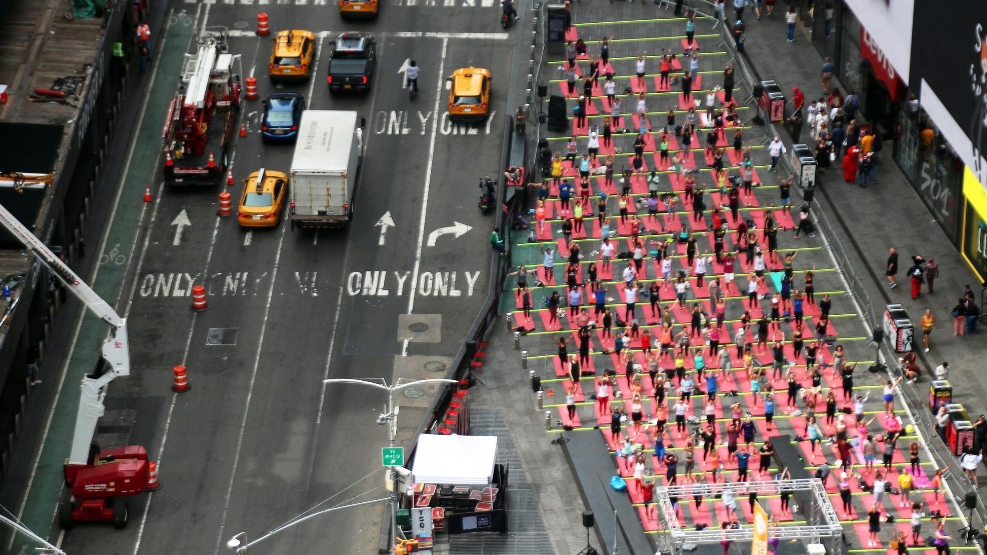 Hunderte Menschen praktizieren 2023 auf dem Times Square anlässlich des Welt-Yoga-Tags Massen-Yoga.