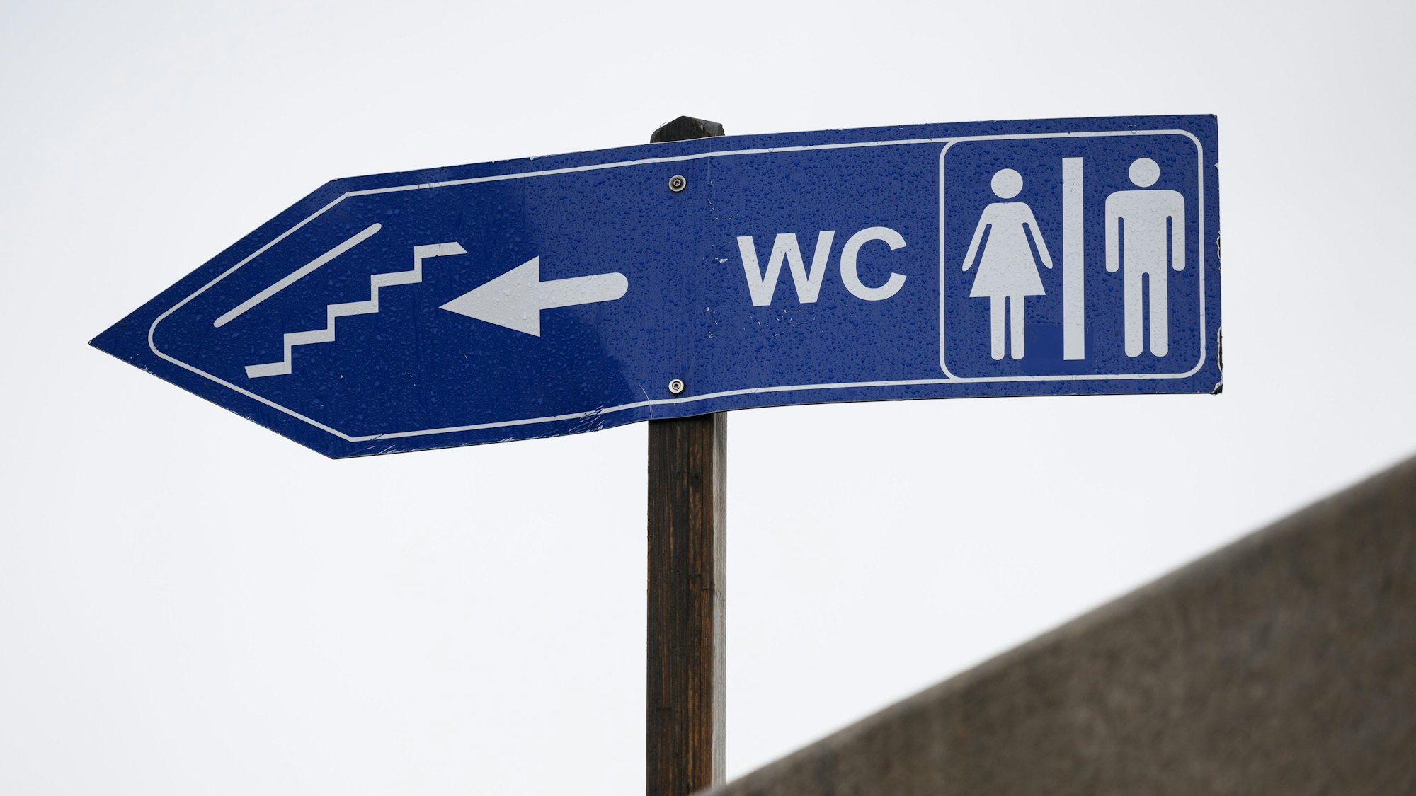 Auf einem Schild werden öffentliche Toiletten ausgewiesen.