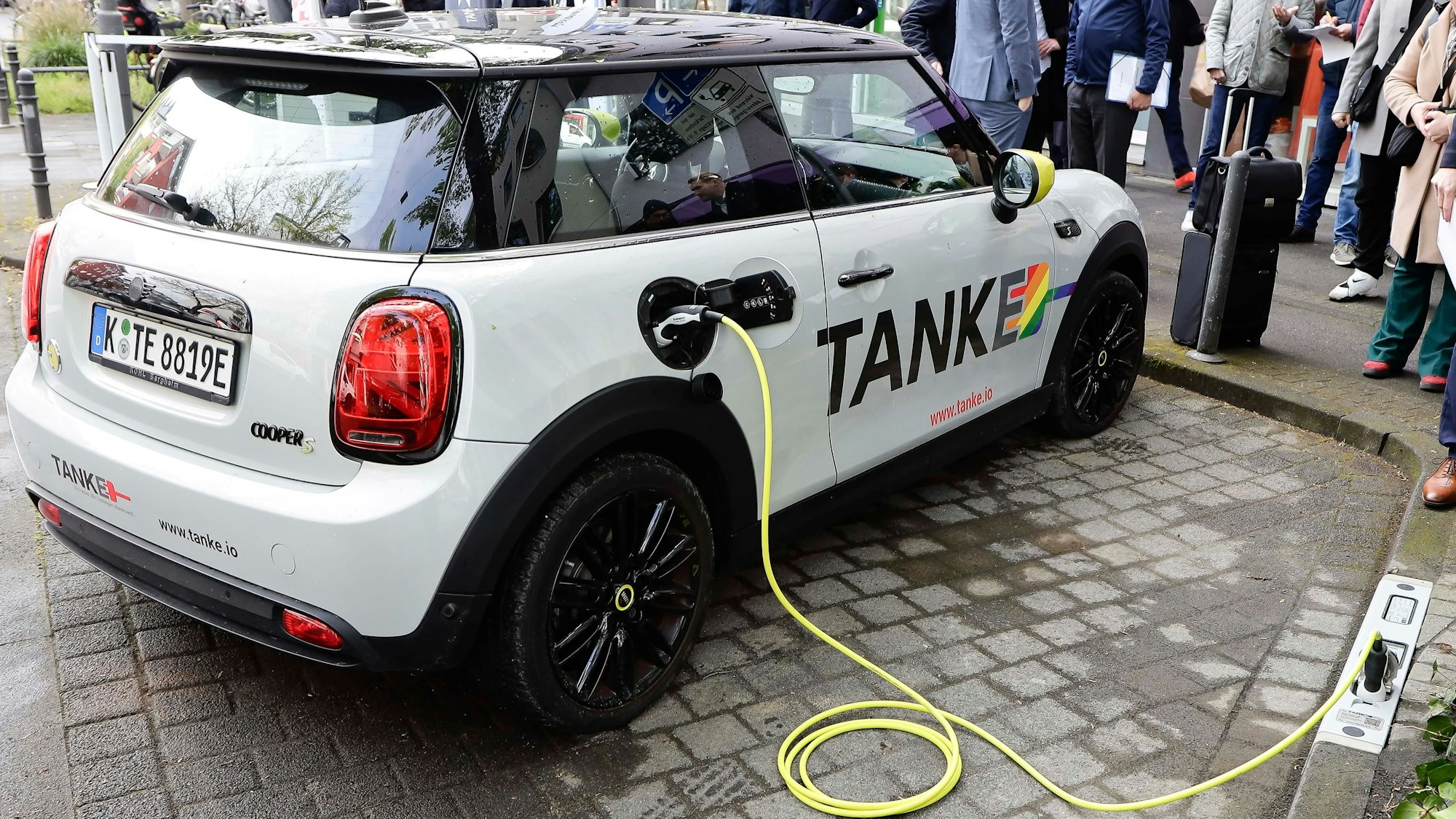 Eine E-Auto wird an der Bordsteinladestation geladen.