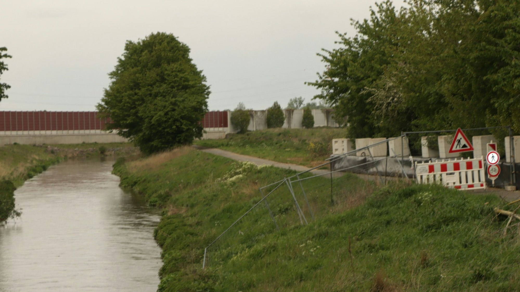 Zu sehen ist die Erft und der gesperrte Radweg am Ufer.