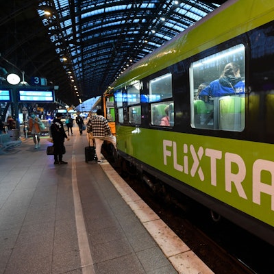 Mehrere Reisende steigen in einen Flixtrain am Kölner Hauptbahnhof, der Zug ist markant grün lackiert. Im Innenraum sind mehrere Fahrgäste zu sehen.