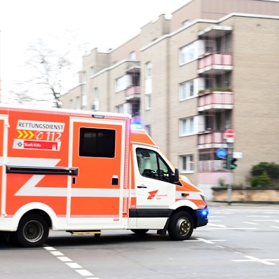 Ein Feuerwehrauto fährt über eine ansonsten leere Straße.