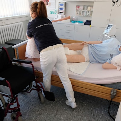 Eine Mitarbeiterin einer Pflegeeinrichtungen demonstriert den Umgang mit Bettlägerigen an einer Puppe.