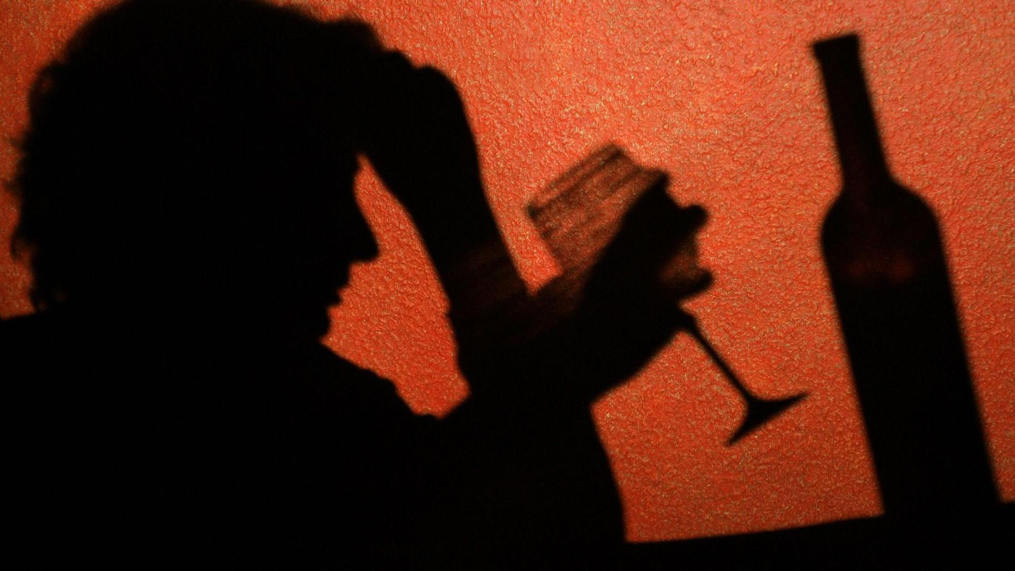 Der Schatten einer Frau, die ein Glas Wein trinkt, ist an der Wand in einer Kneipe in Frankfurt (Oder) zu erkennen. Laut einer aktuellen Studie sterben Alkoholabhängige deutlich früher.