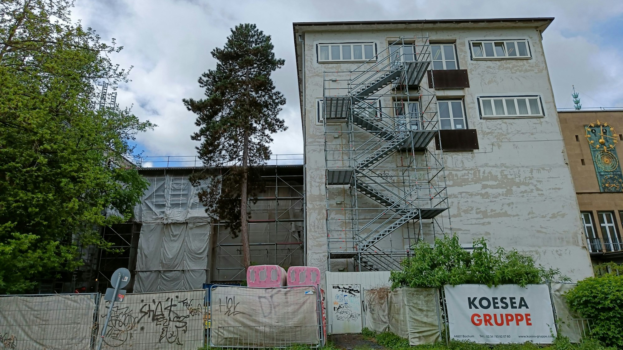 Vor der Fassade eines Gebäudeteils der Rechtswissenschaftlichen Fakultät steht ein Gerüst.