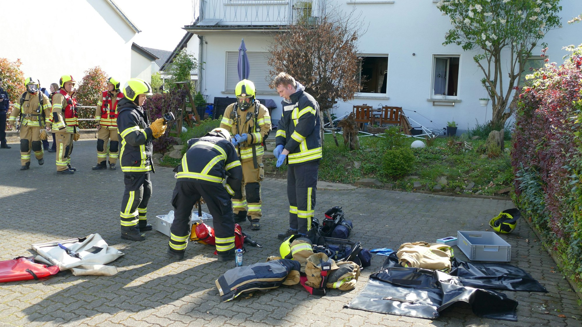 Feuerwehrleute stehen vor der Brandwohnung.