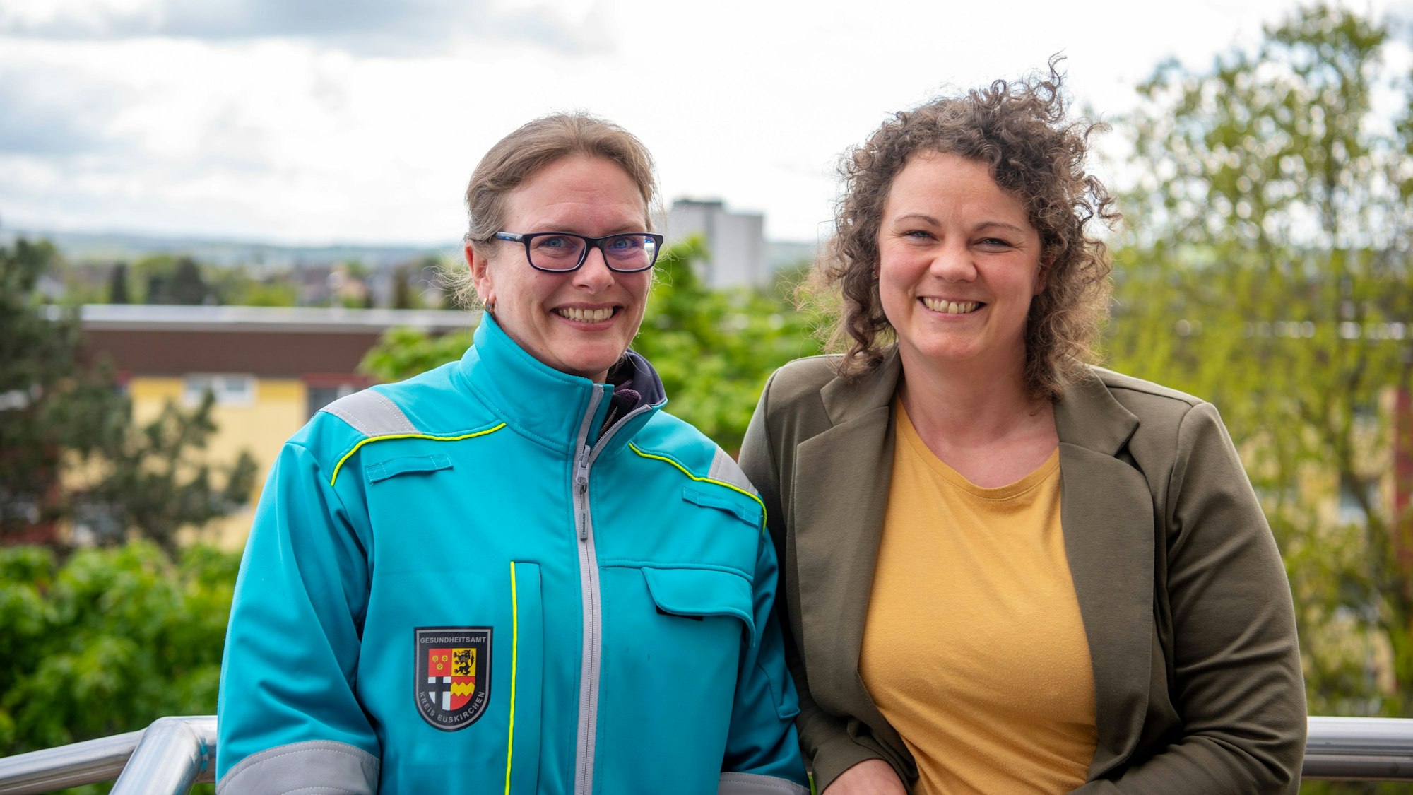 Katja Ziemann (links), Koordinatorin Umweltmedizin beim Kreisgesundheitsamt und Saskia Gall-Röhrig vom Klimaanpassungsmanagement des Kreis Euskirchen stehen auf einem Balkon am Kreishaus.