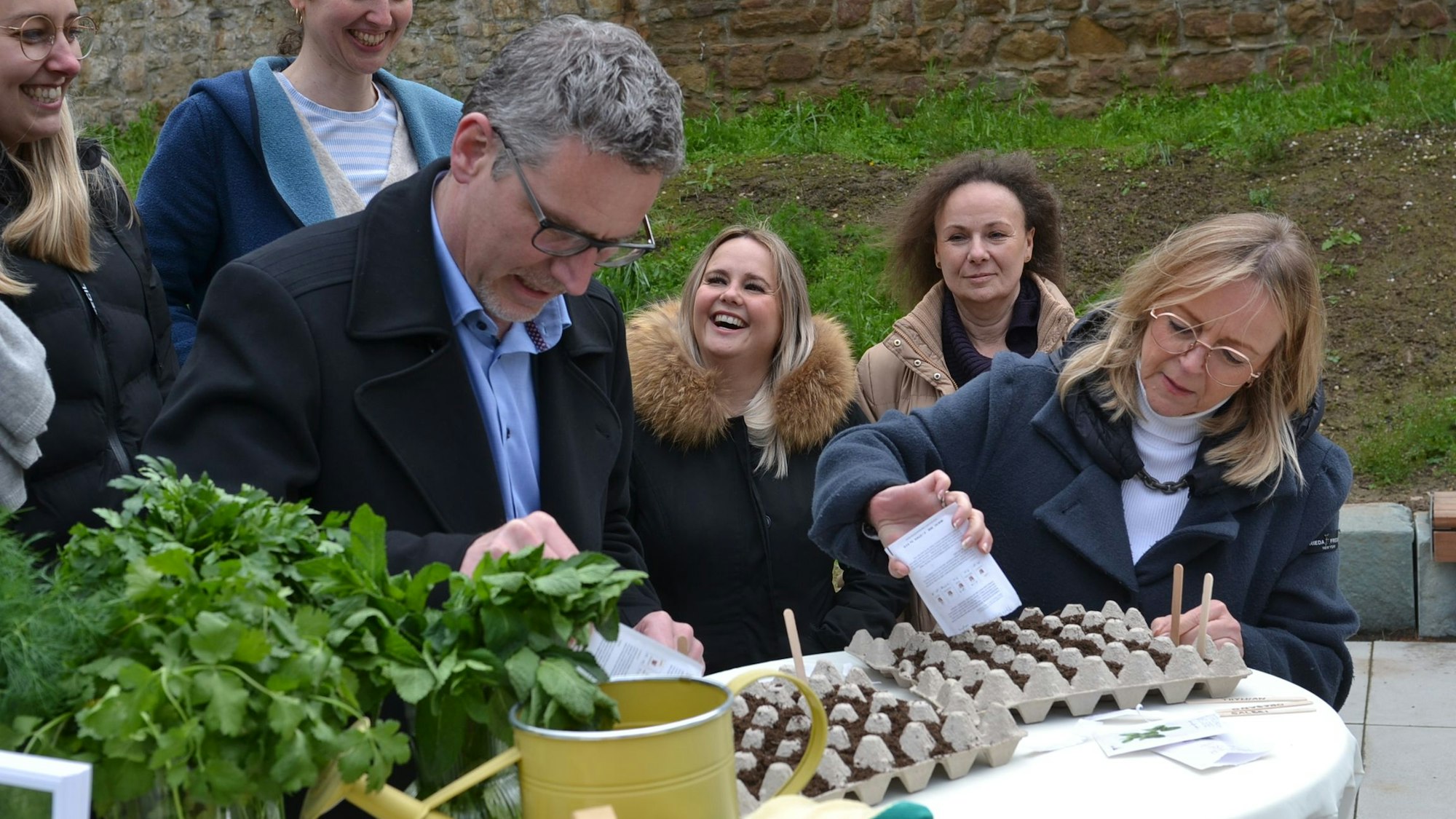 Sabine Preiser-Marian und Norbert Crump schütten Pflanzensamen in einen Eierkarton.
