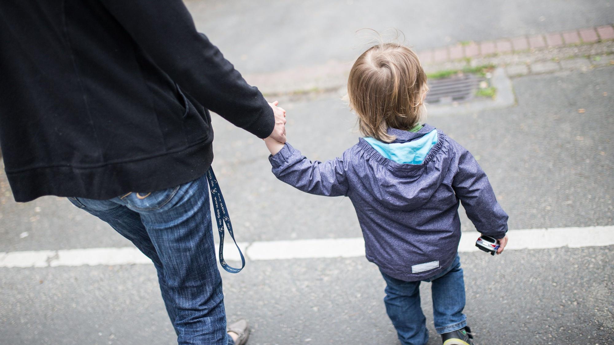 Eine Mutter hält ihren Sohn an der Hand. Alleinerziehende und ihre Kinder sind einer Studie zufolge in deutlich überproportionalem Ausmaß von finanzieller Armut bedroht.