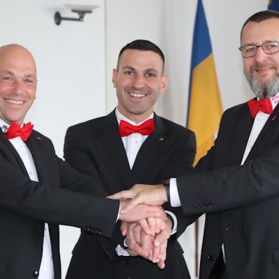 Zu sehen ist das designierte Dreigestirn, das die Hände übereinander hält.