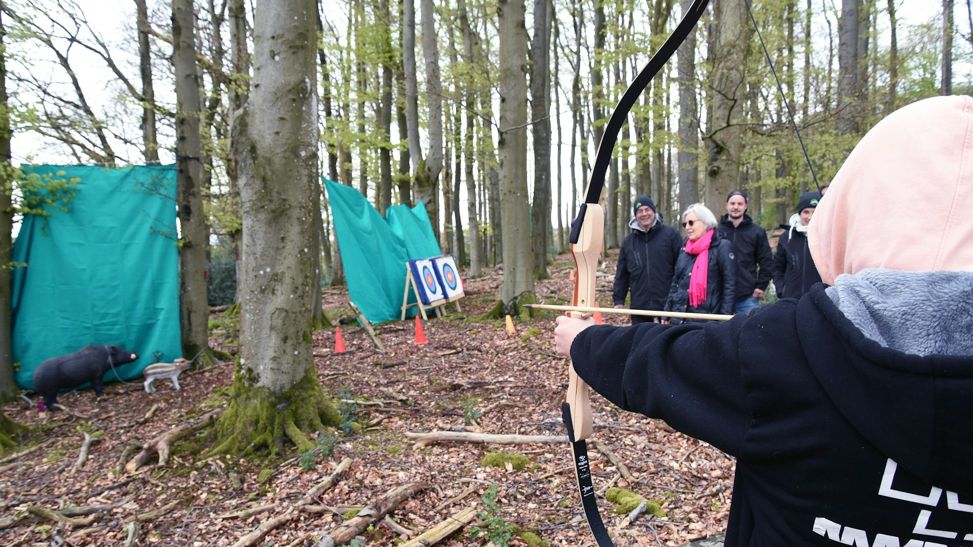 Das Foto zeigt einen Person, die mit Pfeil und Bogen zielt.