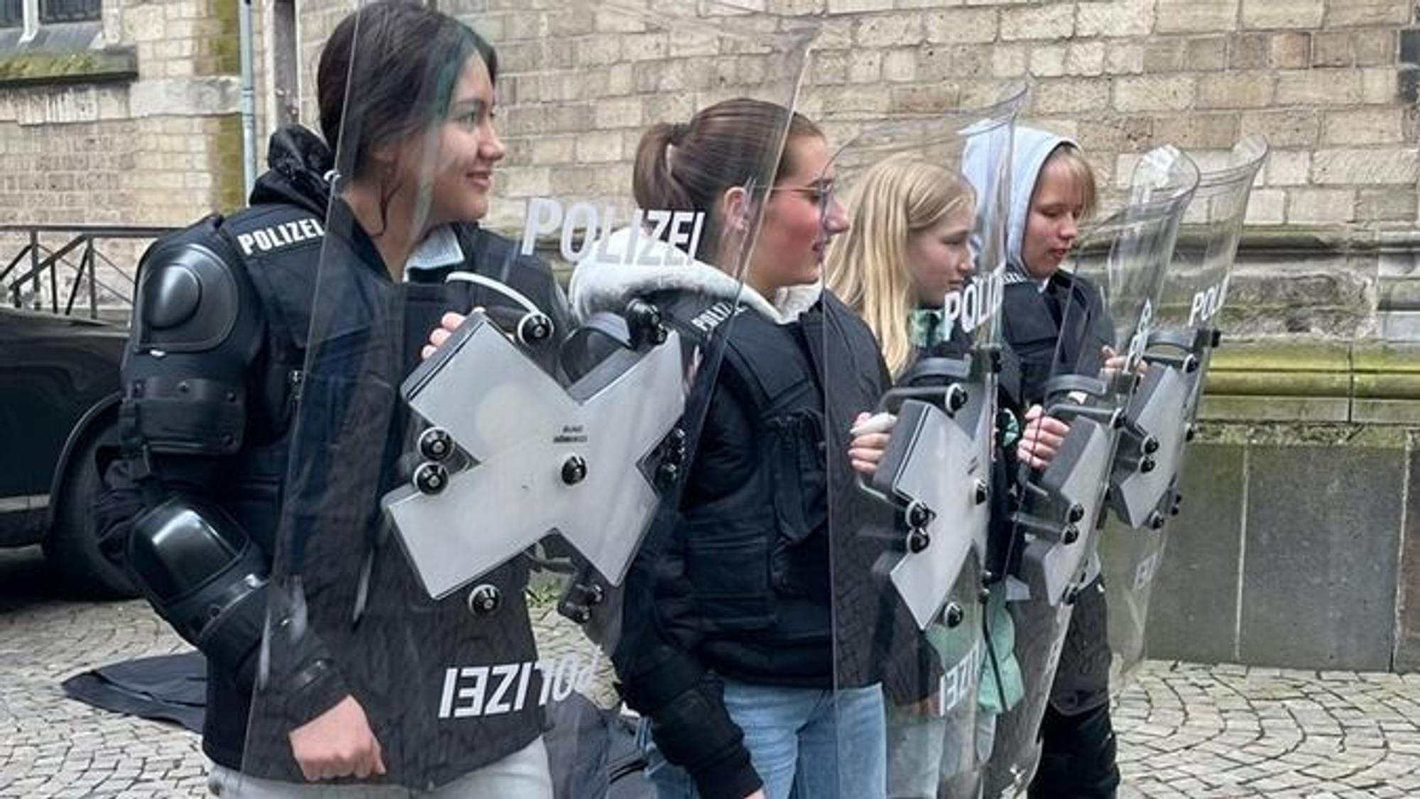 Eine Gruppe von Schülern nimmt an einer praktischen Übung der Polizei teil.