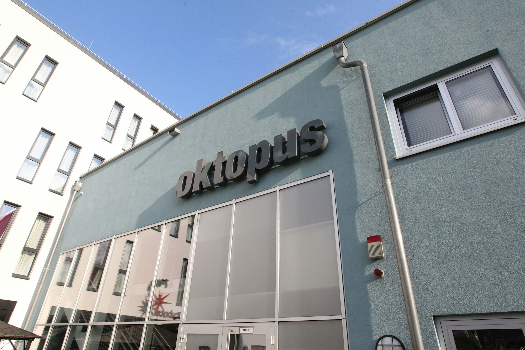 Das Schwimmbad Oktopus in Siegburg: Eine blaue Hausfassade mit Fensterfront und Logo.