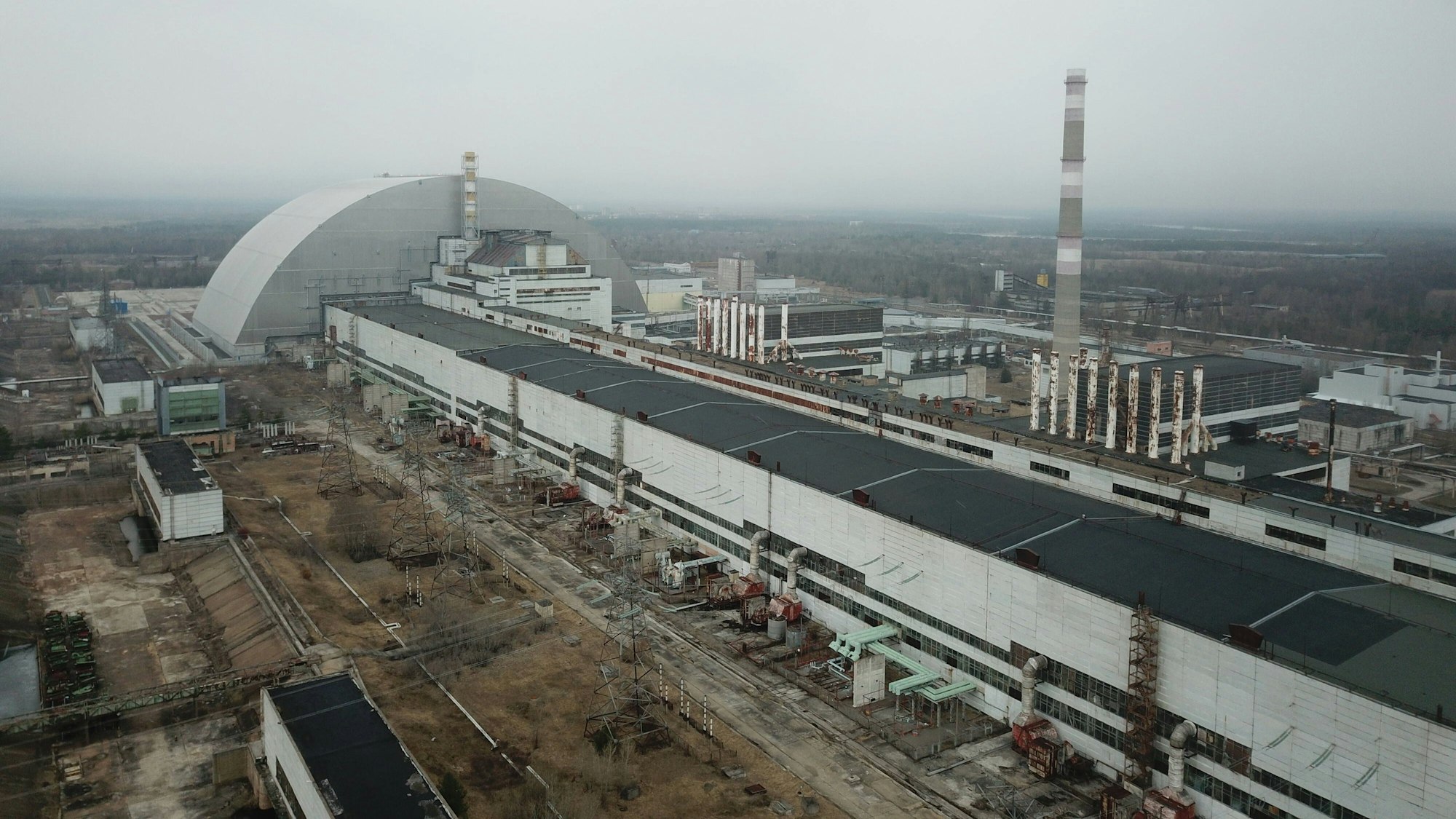 Das Kernkraftwerk in Tschernobyl. Im Hintergrund ist die Schutzhülle um den havarierten Reaktorblock 4 zu sehen. (Archivbild)