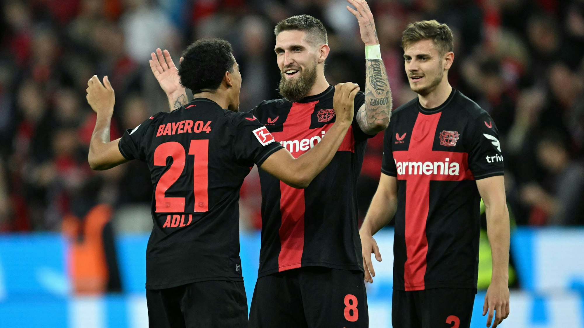 Bayer Leverkusen's French forward #21 Amine Adli, Bayer Leverkusen's German midfielder #08 Robert Andrich and Bayer Leverkusen's Croatian defender #02 Josip Stanisic celebrate after the German first division Bundesliga football match Bayer 04 Leverkusen v VfL Stuttgart in Leverkusen, western Germany, on April 27, 2024. (Photo by INA FASSBENDER / AFP) / DFL REGULATIONS PROHIBIT ANY USE OF PHOTOGRAPHS AS IMAGE SEQUENCES AND/OR QUASI-VIDEO