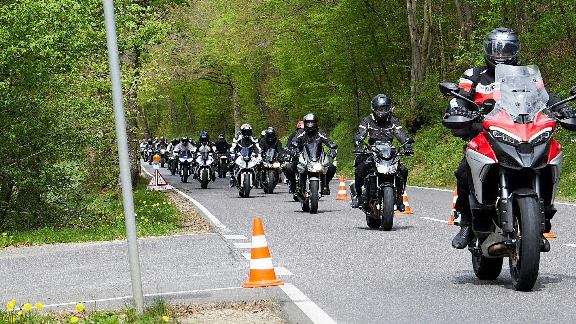 Zahlreiche Motorradfahrer fahren in einem Pulk dem Weg zum Nürburgring.