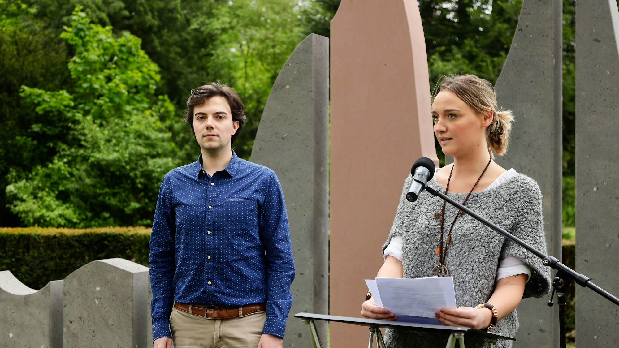 Ein Schüler und eine Schülerin vor dem Denkmal