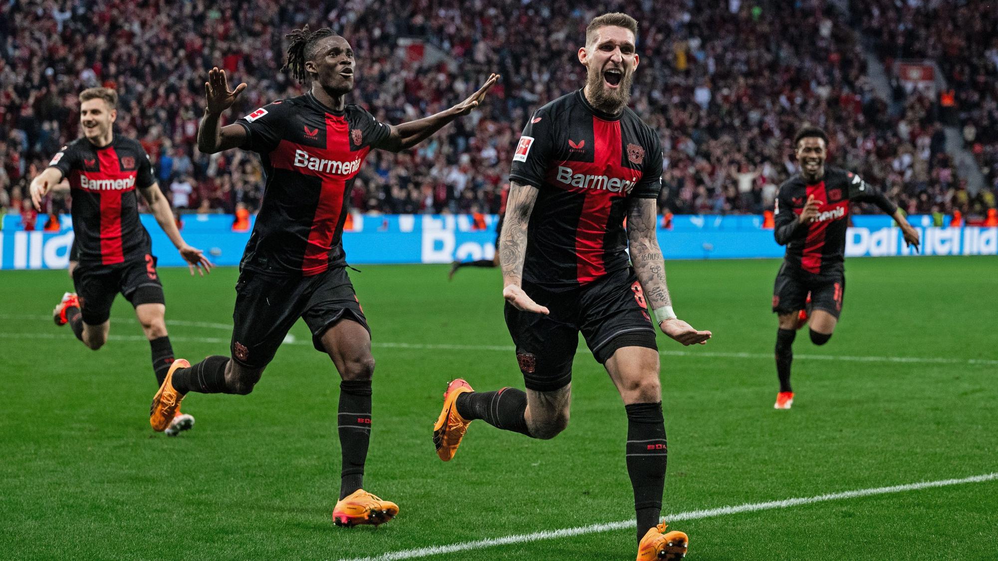 dpatopbilder - 27.04.2024, Nordrhein-Westfalen, Leverkusen: Fußball: Bundesliga, Bayer Leverkusen - VfB Stuttgart, 31. Spieltag, BayArena. Leverkusens Josip Stanisic (l-r), Odilon Kossounou und Torschütze Robert Andrich jubeln nach dem Treffer zum 2:2 Ausgleich. Foto: Marius Becker/dpa - WICHTIGER HINWEIS: Gemäß den Vorgaben der DFL Deutsche Fußball Liga bzw. des DFB Deutscher Fußball-Bund ist es untersagt, in dem Stadion und/oder vom Spiel angefertigte Fotoaufnahmen in Form von Sequenzbildern und/oder videoähnlichen Fotostrecken zu verwerten bzw. verwerten zu lassen. +++ dpa-Bildfunk +++