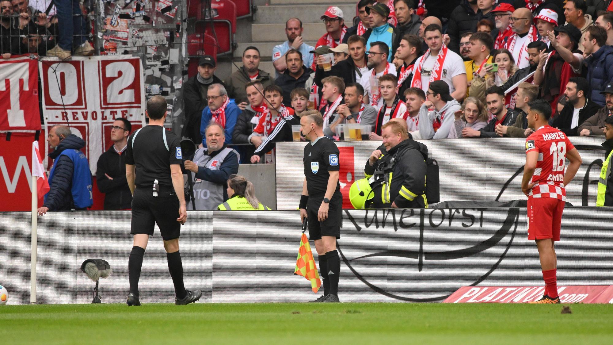 Kölner Fans bewerfen den Mainzer Nadiem Amiri (r) bei seiner Ecke mit Gegenständen.