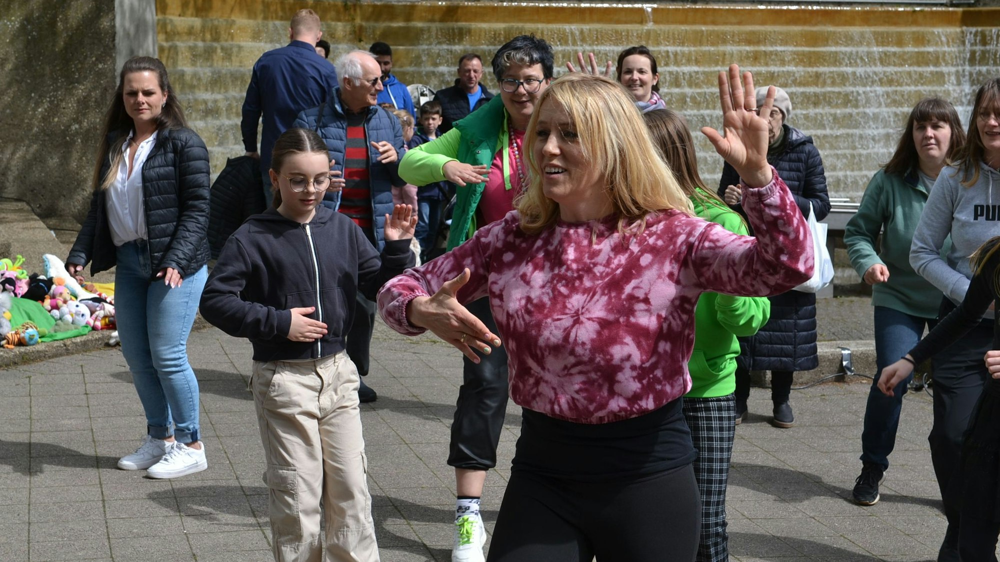Das Bild zeigt eine Tanzlehrerin der Tanzschule Schumacher. Im Hintergrund sind einige spontane Mittänzer zu sehen.