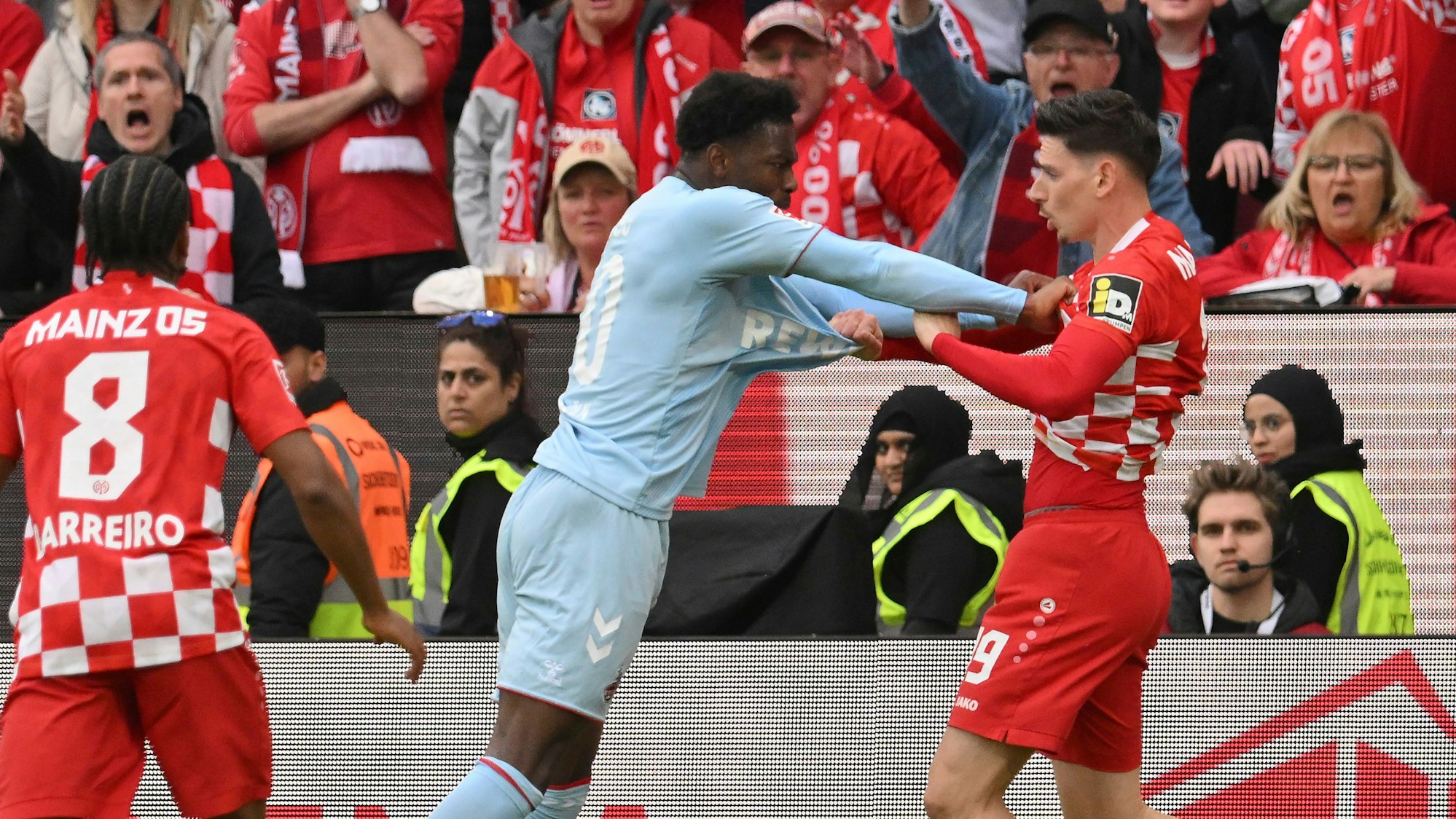 Der Mainzer Anthony Caci (r) rangelt mit Kölns Faride Alidou (M).