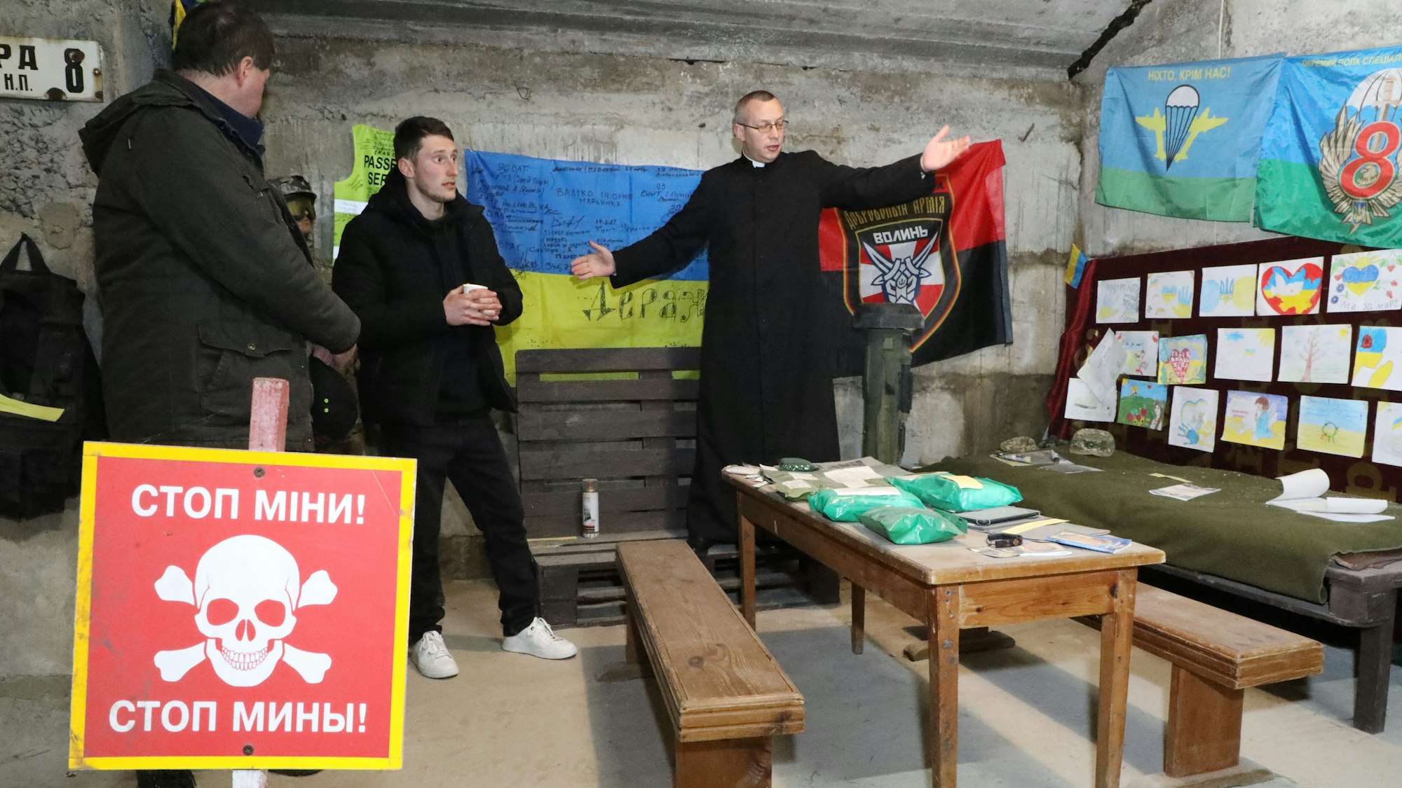 Pfarrer Mikola Lutschinsky steht im Keller seiner Kirche und erläutert die hier zusammengetragenen Mahnmale des Krieges, an die Opfer dahinter erinnert.