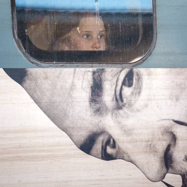 A child looks out from the window of a train displaying an advert to a Salvador Dali exhibition, at Gara de Nord, the main railway station in Bucharest, Romania,