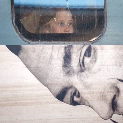 A child looks out from the window of a train displaying an advert to a Salvador Dali exhibition, at Gara de Nord, the main railway station in Bucharest, Romania,
