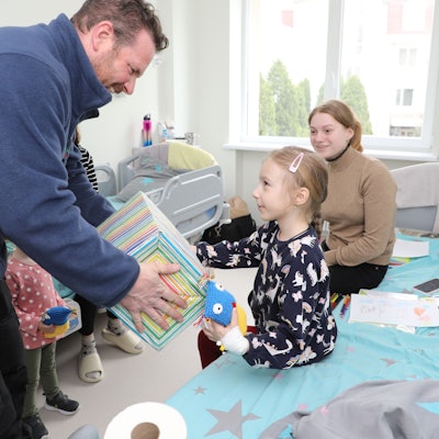 Thomas Migenda von der Humanitären Hilfe Overath überreicht einem Kind in der Kinderklinik Lviv ein Geschenk.