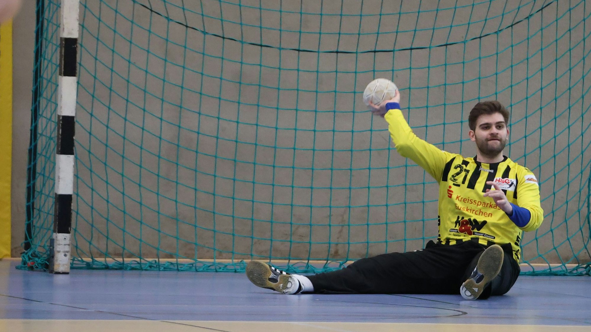 Euskirchens Torwart Aaron Wilden sitzt vor dem Tor auf dem Boden und hält den Ball in der Hand.