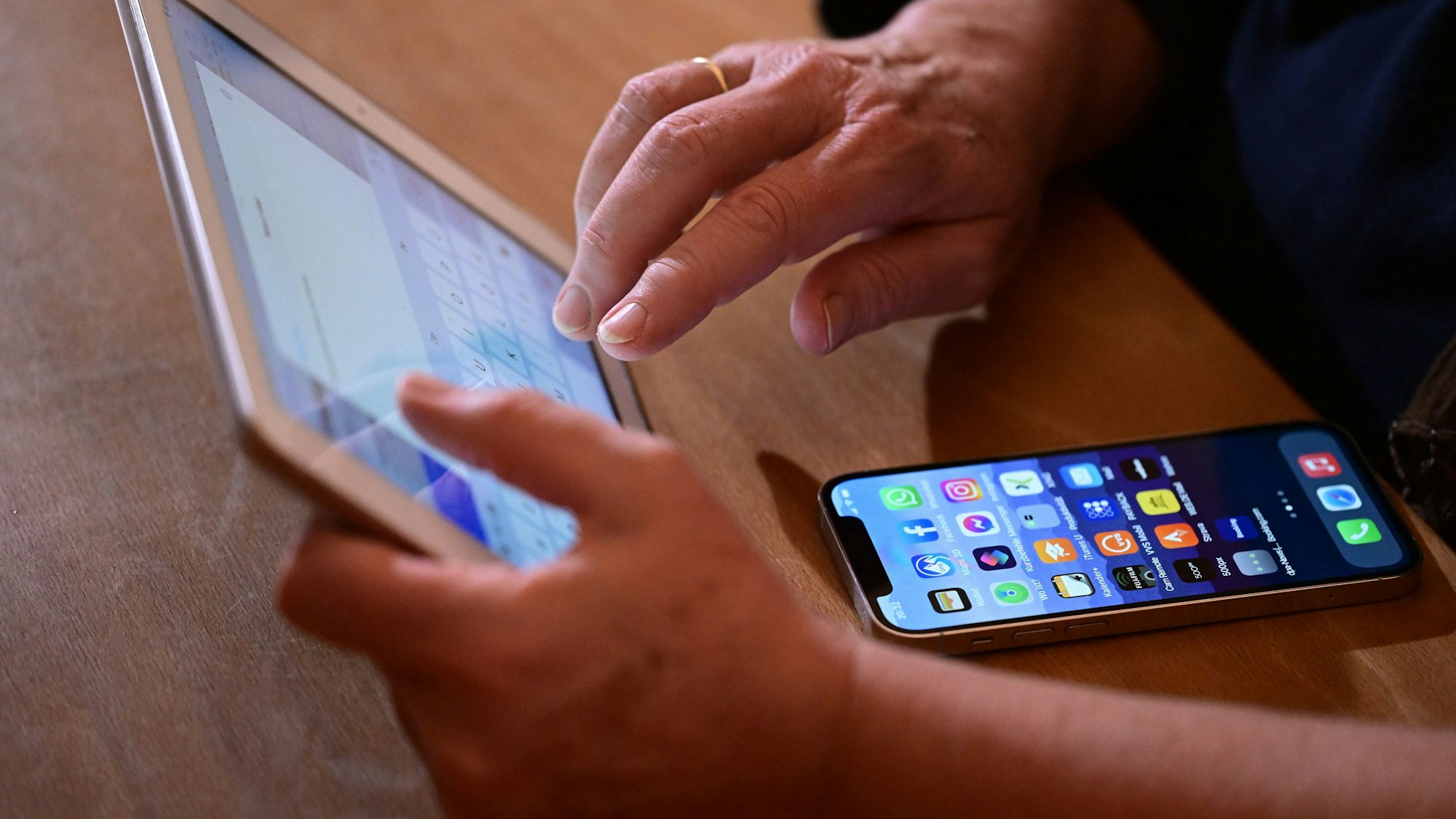 Eine Frau tippt auf einem iPad eine Mail (gestellte Szene).