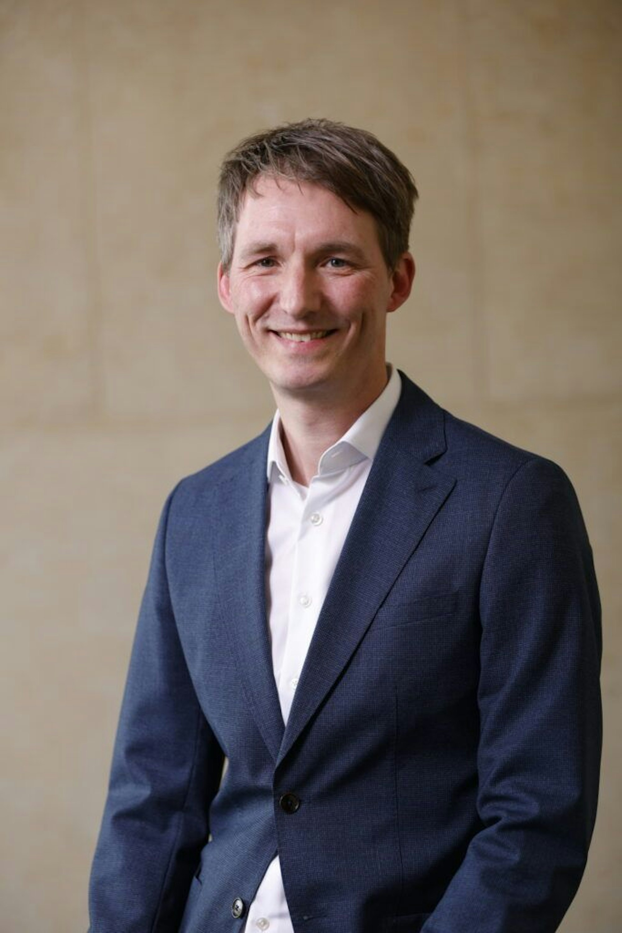 Ein Mann im Anzug schaut in die Kamera